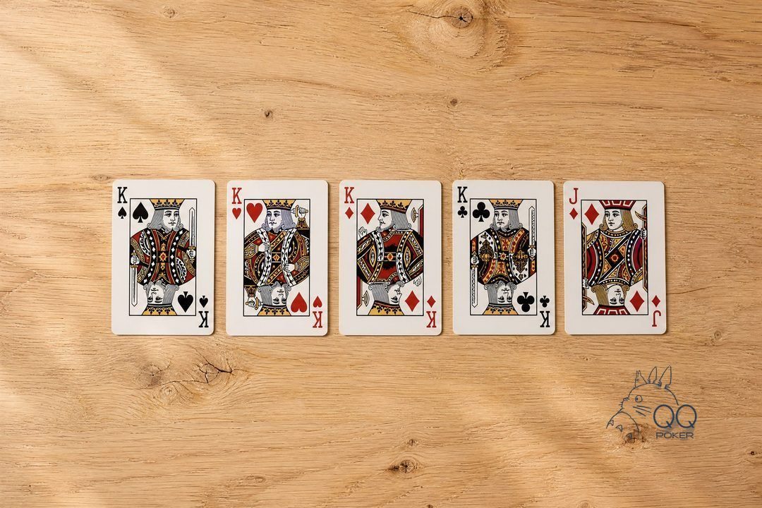 五张正面朝上的牌一字横排：黑桃 K、红桃 K、方块 K、梅花 K 带方块 J，四条，微俯